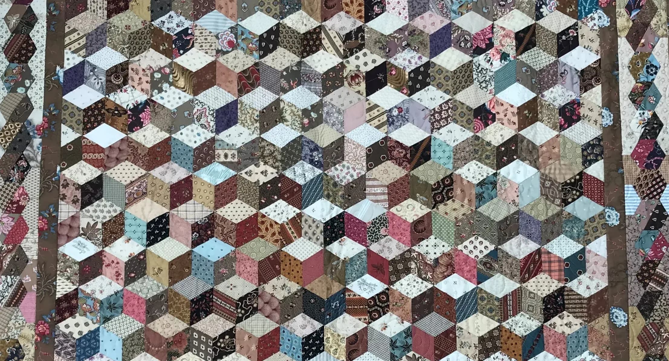 Op deze foto zie je een groot stuk patchwork of quiltwerk. De foto is van Archief Eemland